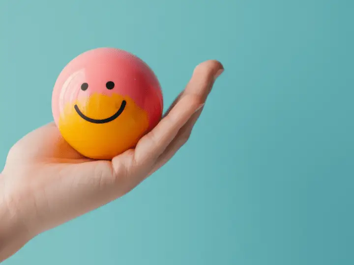Dialectical Behavior Therapy - A smiley face ball being held.