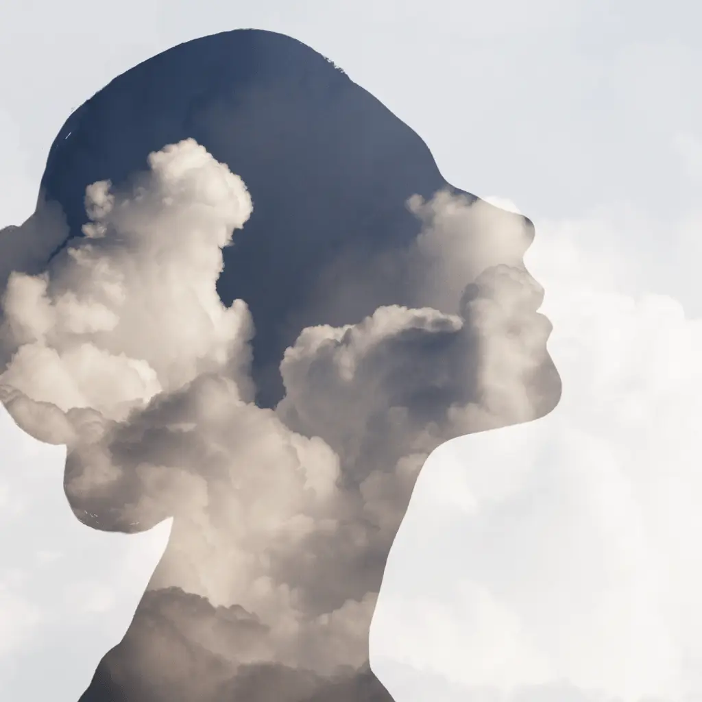 A silhouette of a woman’s face with clouds, symbolizing the connection between sleep, mental health, and relaxation.