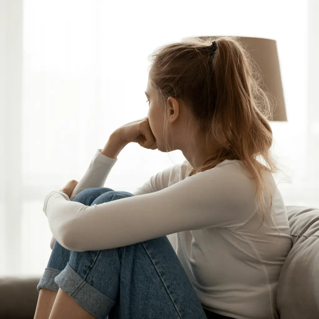 Woman sitting in solitude looking thoughtful, reflecting emotional challenges addressed in pornography addiction therapy