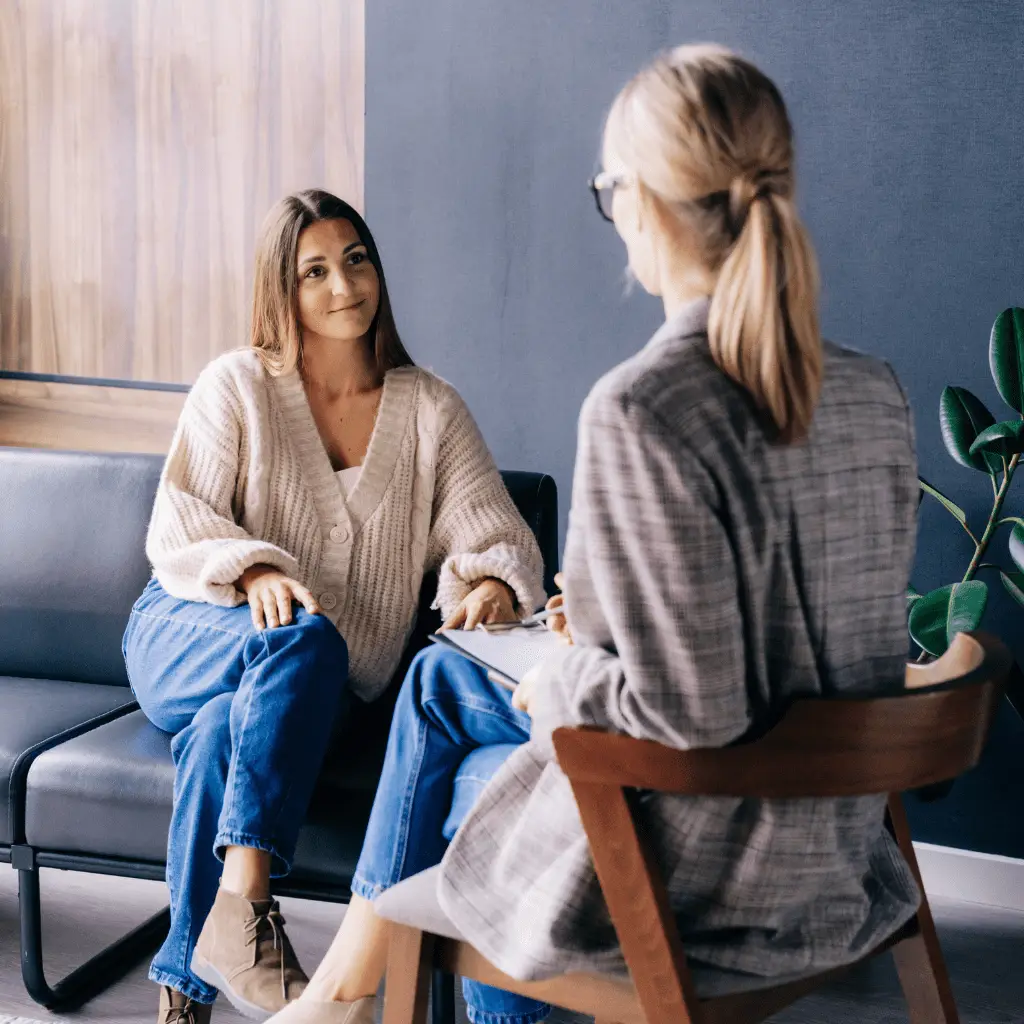 Counselor and therapist meeting with client in Utah office discussing mental health goals.